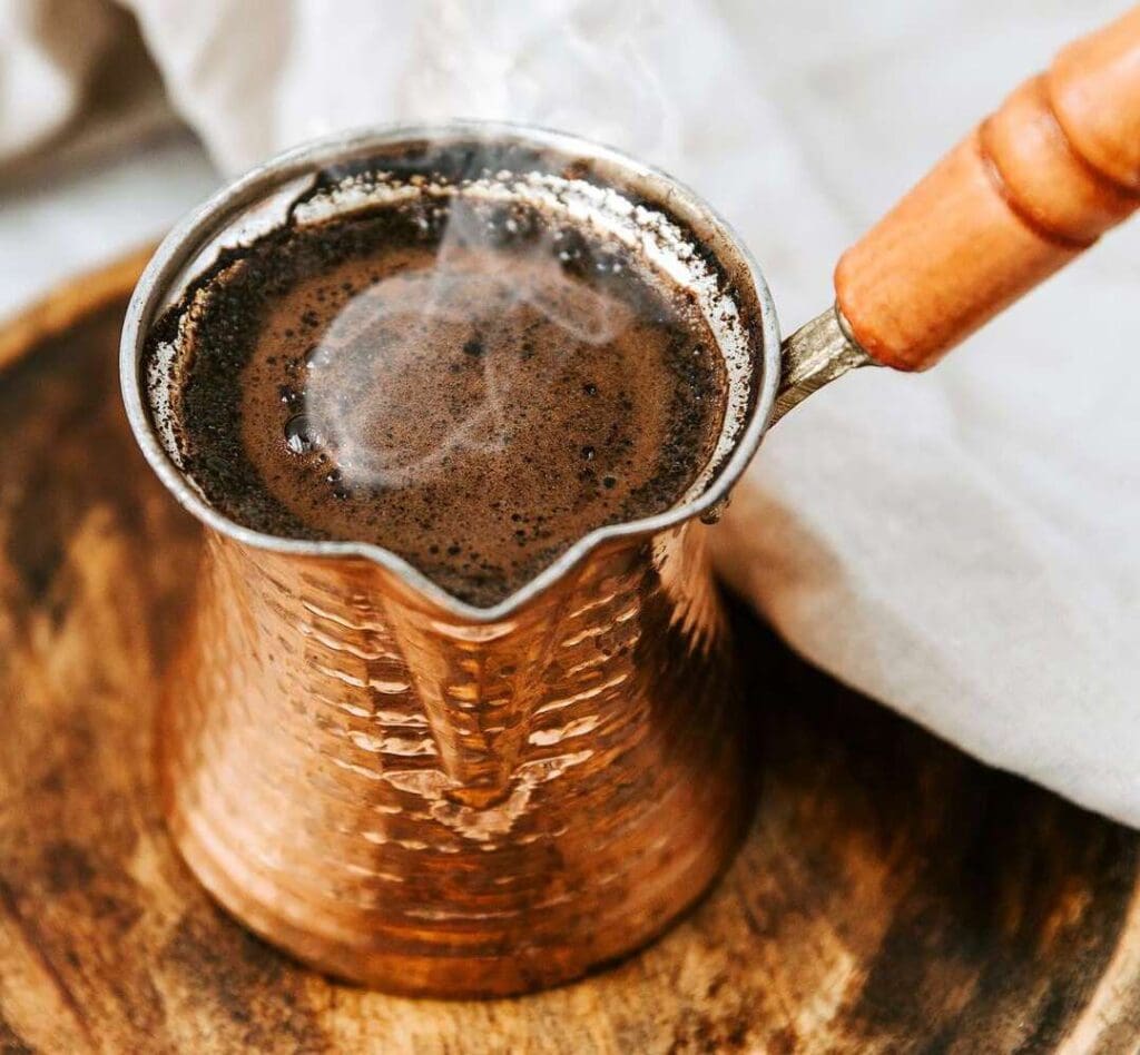 a copper pot with a brown liquid in it